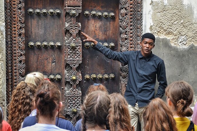 Tour guide showing historic site in Stone Town to a Family