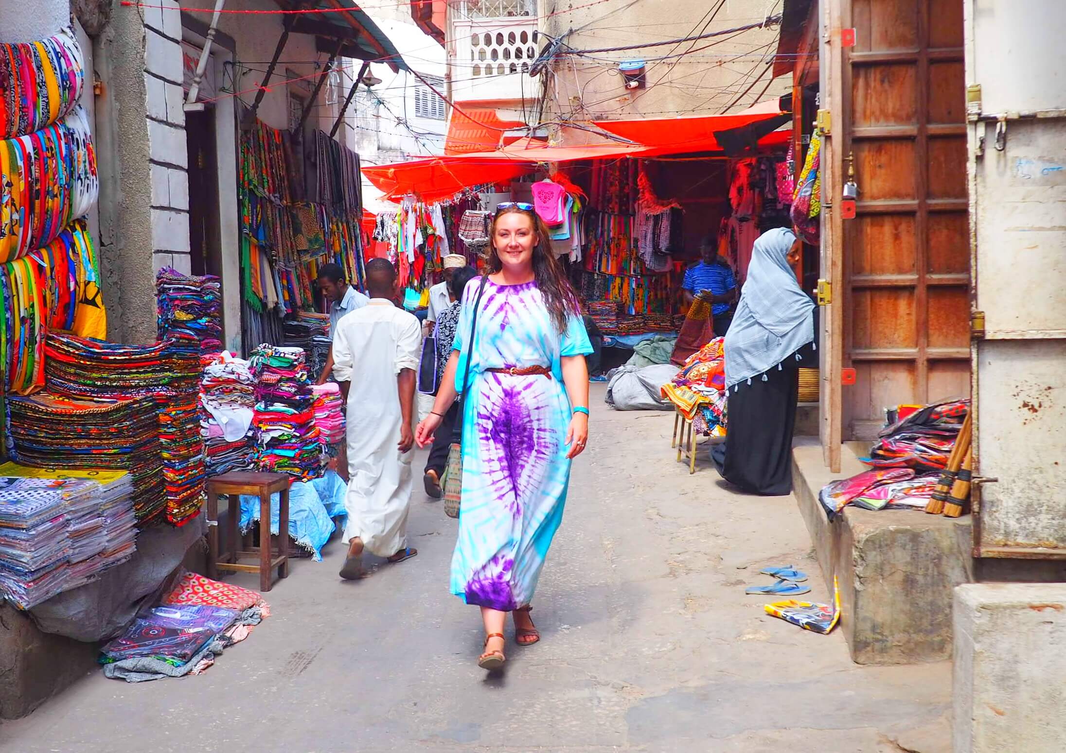 tourist exploring the historic streets of Stone Town, Zanzibar, dressed in culturally respectful clothing